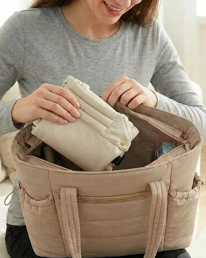 Porte‑bébé physiologique beige plié — compact pour rangement et transport