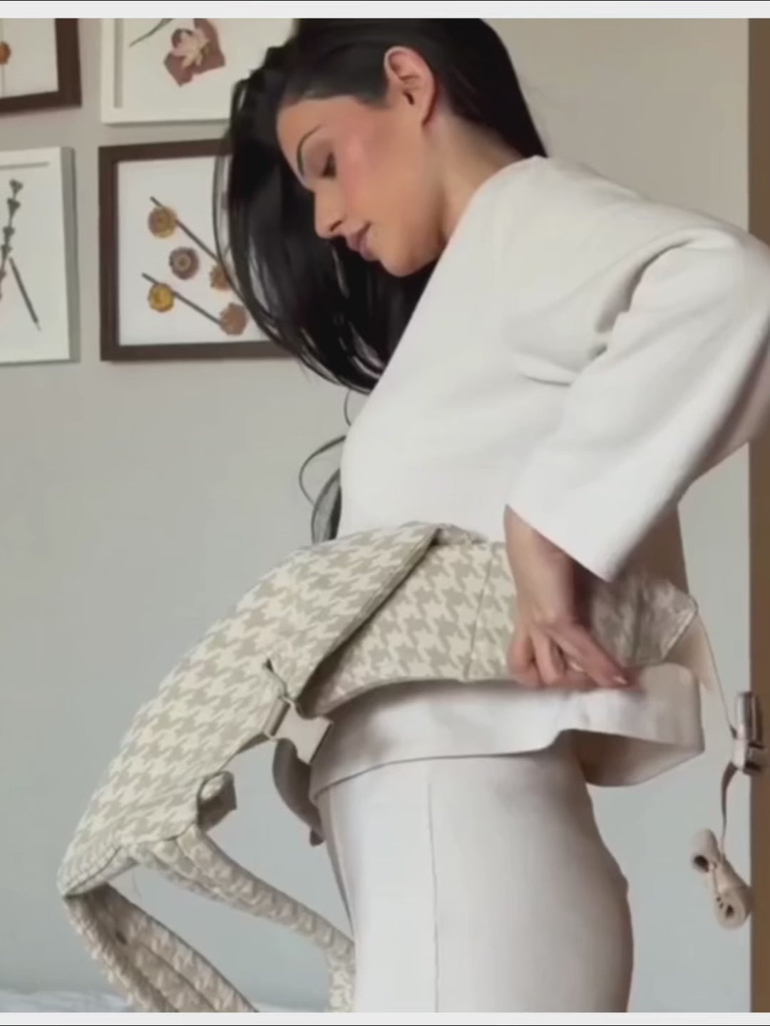Vidéo tutoriel seconde montrant comment mettre le porte‑bébé physiologique gris à carreaux — étapes : positionnement ceinture, réglage panneau, insertion du bébé, ajustement bretelles et sécurité des clips