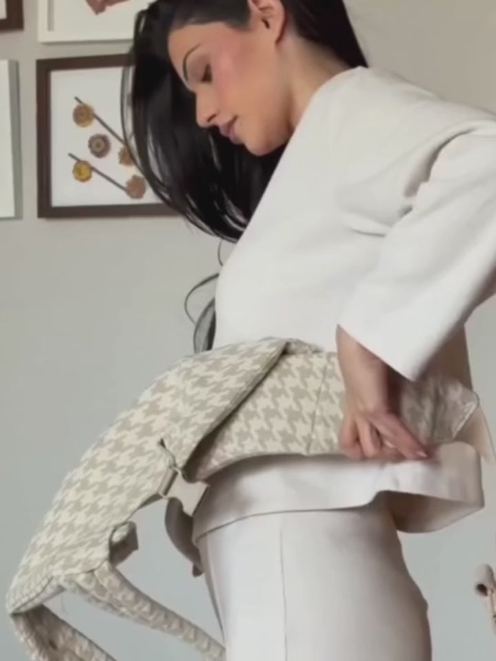 Vidéo tutoriel montrant comment mettre le porte‑bébé physiologique gris à carreaux — étapes : positionnement ceinture, réglage panneau, insertion du bébé, ajustement bretelles et sécurité des clips
